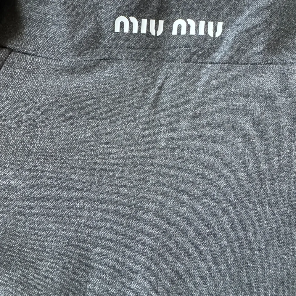 Snygg grå kortkjol från Miu Miu med en stilren design. Kjolen har en bred linning och är perfekt för en chic look. Den är tillverkad i ett mjukt material som ger en bekväm passform.. Hameet.