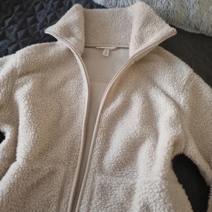 Beige teddyjacka med dragkedja från H&M.  - Mysig beige teddyjacka med dragkedja framtill. Perfekt för kyliga dagar med sin fluffiga och varma design. Jackan har en hög krage och långa ärmar för extra komfort. Den är helt såld. Jätte populär i storlek S. 