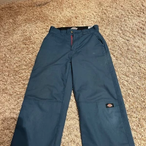 Blå arbetsbyxor från Dickies - Säljer ett par blå arbetsbyxor från Dickies Skateboarding-kollektion. Byxorna har en loose passform och är tillverkade i slitstarkt material med flex för extra komfort. De har flera praktiska fickor och en diskret logga på benet.