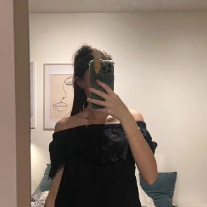 Svart offshoulder topp med spetsdetaljer - Snygg svart offshoulder topp med spetsdetaljer från Gina tricot. Toppen har en elastisk kant för bekväm passform. Kommer passa en XS/S