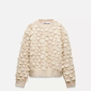 Beige tröja med blommor från Zara - Säljer en unik beige tröja från Zara med 3D-blommor över hela ytan. Tröjan har långa ärmar och ribbade muddar vid ärmslut och nederkant. Perfekt för att ge din outfit en extra touch! 🌸