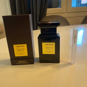 Tom Ford Tobacco Vanille Eau de Parfum 10Ml - Exklusiv parfym från Tom Ford, Tobacco Vanille, i en elegant mörkbrun flaska med guldfärgad etikett. Flaskan rymmer 10 ml och har en lyxig och sofistikerad doftprofil med inslag av tobak och vanilj. Perfekt för den som söker en unik och djärv doftupplevelse.