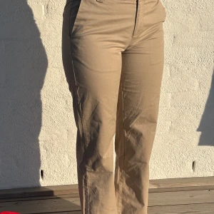 Beige chinos från Nelly, raka ben - Supersnygga och tidlösa chinos i beige från Nelly. Sitter jättefint med rak passform, klassisk midja och lagom långa ben. Funkar till allt – vit skjorta, stickad tröja eller en basic tee. Fickor fram & bak + bälteshällor.  📏 Strl 36 🧵 100 % bomull 🧺 Fräscha och i väldigt fint skick 💬 Skriv om du vill ha fler bilder eller mått! 📬 Skickas snabbt 💨 
