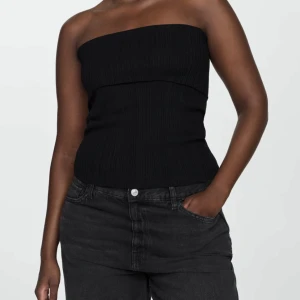 Svart ribbad bandeau tubtopp - Säljer en svart ribbad bandeau tubtopp med stretchig passform som tyvärr sitter för löst på mig :(  Toppen är från and other stories och i mycket bra kvalitet!!!  Materialet är mjukt och följsamt, vilket gör den superbekväm att bära. Passar snyggt till både jeans och kjol.