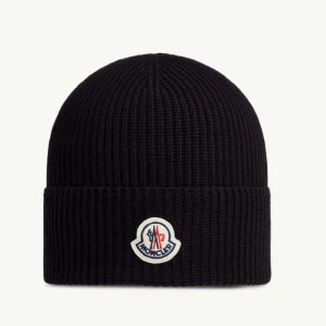 Svart Moncler mössa - Svart ribbstickad mössa från Moncler. Säljer för att den inte kommer till användning. Ny på hemsidan kostar 2960kr. Skriv om frågor eller bilder .