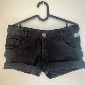 Svarta lågmidjade shorts - Svarta lågmidjade shorts från Tokyo NXTL med klassisk femficksdesign och uppvikta benslut. De är lite större i storleken. Shortsen är tillverkade i ett mjukt bomullstyg. Perfekta för varma dagar och enkla att matcha med allt!❤️