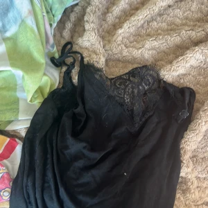 Svart spetsklänning från Cubus XS - Supersnygg svart kortklänning från Cubus i storlek XS. Klänningen har tunna axelband, v-ringning och vacker spetsdetalj upptill. Perfekt för dig som gillar en stilren look med lite extra edge. Materialet känns mjukt och följsamt.