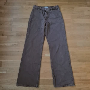 Bruna raka jeans från Zara, strl 40 - Säljer ett par brun/grå jeans från Zara i storlek 40. De har raka ben, klassisk femficksmodell och bälteshällor. Jeansen är i bomull och har en snygg, lite vintagebrun ton. Perfekta för dig som gillar en avslappnad och stilren look.