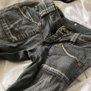 Levi's 501 grå jeans med slitningar - Säljer ett par klassiska Levi's 501 jeans i grått med snygga slitningar