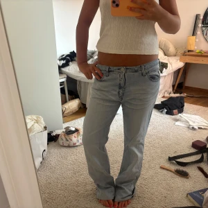 Ljusblå raka jeans låg midja - Säljer ett par ljusblå jeans med låg midja och raka ben. Jeansen har klassisk femficksdesign och är tillverkade i mjukt denimtyg. Perfekta för en avslappnad och trendig look.