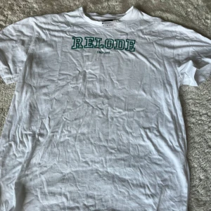 Vit t-shirt från Relode - Vit t-shirt från Relode med grönt tryck på bröstet. Oversized