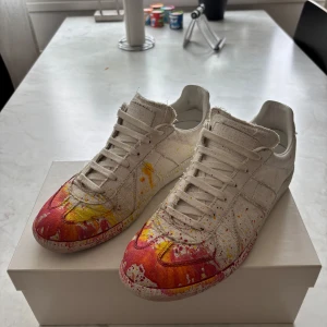 Maison Margiela Paint Splatter Gats | 41 - Unika sneakers från Maison Margiela i canvas med handmålat färgstänk, Utmärkt skick med nästintill inga tecken på användning. Skon är stor i storleken så passar upp till 41-42, Fråga gärna om mått eller fler bilder! ÄR VILLIG ATT GÅ NER I PRIS 