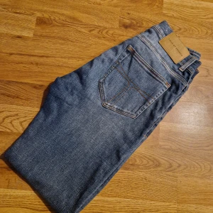Blå jeans från Tiger of Sweden! Waist: 30 Length: 32 - Snygga blå jeans från Tiger of Sweden. Perfekta för en avslappnad och stilren look. Storlek W30/L32.                                     Modell EVOLVE.                                      Mycket fint skick, djur och rökfritt hem!                                  NYPRIS: 1599:- 