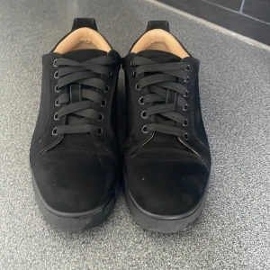 Svarta sneakers i mocka med snörning - Stilrena svarta sneakers i mocka med svarta snören och rund tå. Skorna har en platt sula och beige innersida för extra kontrast. Perfekta för dig som gillar en clean och klassisk look.