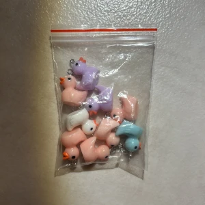 Pastellfärgade ank berlocker till smycken - Säljer ett gäng söta ank berlocker i pastellfärger – ljusrosa, lila, blå och vit. Perfekta att använda till att göra egna halsband, armband eller örhängen. Varje anka har en liten ögla för att enkelt fästa på smycken. Supergulliga och unika detaljer till din smyckestillverkning!