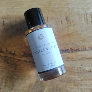 Vanilla Lust  50ml från Curiosa - Vanilla Lust No. 045 från Curiosa är en parfym med varm, bärnstensfärgad vätska i en stilren, cylindrisk glasflaska med svart plastlock. Flaskan rymmer 50 ml. Perfekt för dig som älskar söta, vaniljiga dofter.