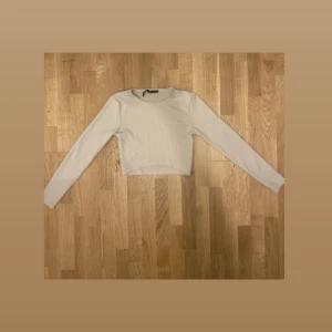 Zara Cremefärgad Långärmad Magtröja - Säljer en Cremefärgad långärmad magtröja från Zara i storlek EUR L (USA L, MEX 30). Tröjan är kortare i modellen och sitter snyggt på kroppen. Perfekt för att styla med jeans eller kjol. Tillverkad i Turkiet och i mycket bra skick.