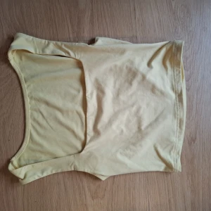 Ljusgul ärmlös linnetopp - Snygg ljusgul linnetopp med enkel och clean design. Toppen är ärmlös och har en rundad halsringning, perfekt att matcha med jeans eller kjol. Mjuk och stretchig bomullskänsla som gör den superbekväm att bära. Vet inte var den är ifrån då jag fick den i present och den inte har någon lapp. Är ganska kort men är perfekt till träningspass eller bara ett fin linne på en varm  sommardag. Säljer då den inte riktigt föll mig i smaken.