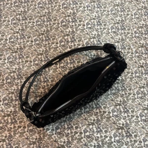 Svart axelväska med paljetter - Säljer en svart axelväska men paljetter på. Aldrig använd men köpt från shein så där är ingen prislapp.