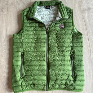 Colmar väst - Snygg grön dunväst från Colmar med quiltad design och dragkedja framtill. Västen har två fickor med dragkedja och en hög krage. Perfekt för lager-på-lager och chillare dagar. Märke på bröstet och liten logga bak.
