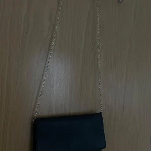 Clutch med kedja - Säljer denna fina clutch väska som man kan ha till fester eller ute när man träffar folk, rymmer relativt mycket och är en väldigt basic fin väska som passar till allting💕