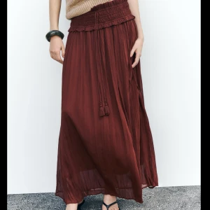 Zara kjol - Brun/röd långkjol från Zara i storlek M. Räfflad detalj i midjan med snören (går ej dra åt). Kjolen är i nyskick med lapp kvar! Nypris 399, slutsåld hos Zara. Säljer då den var lite för kort för min smak! Skriv för detaljer eller om ni har frågor!💕Bilderna tagna från Zaras hemsida!