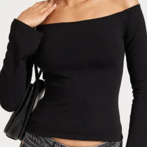 Svart offshoulder topp - Säljer en svart offshoulder topp med lång ärm och tight passform. Toppen har en stilren, enkel design och är perfekt att matcha med jeans eller kjol. Gjord i mjukt bomullsmaterial som sitter skönt mot kroppen.