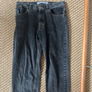Svarta jeans från Polar Denim, 32/32 - Snygga svarta jeans från Polar. Denim i rak modell med klassisk femficksdesign. Jeansen har en cool tvättad look och orangea kontrastsömmar. Perfekta för dig som gillar en avslappnad och tidlös stil.
