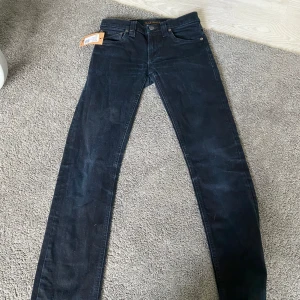 Svarta slim fit jeans från nudie - Snygga svarta jeans från Nudie Jeans med klassisk femficksdesign och slim fit passform