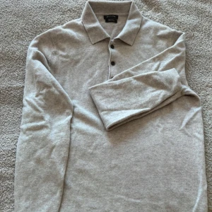 Beige polotröja i ull/kashmir Massimo Dutti - Snygg beige polotröja från Massimo Dutti i en lyxig mix av ull och kashmir. Tröjan har klassisk krage, tre knappar framtill och långa ärmar. Perfekt för dig som gillar stilrena och mjuka plagg med premiumkänsla.