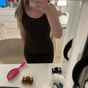 Brun tight klänning  - Säljer en brun, tight och klänning med rund halsringning. Klänningen är enkel och stilren, perfekt för dig som gillar en minimalistisk look. Modellen är kroppsnära och har en klassisk, rak passform.