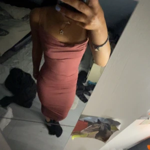 Rosa tight långklänning med smala band - Säljer en snygg rosa långklänning med smala axelband och draperad urringning. Klänningen är tight och har en stilren, enkel design som framhäver figuren. Perfekt för dig som gillar minimalistisk och trendig stil.