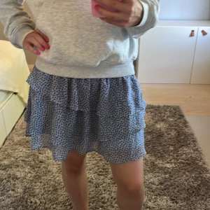 Blå volangkjol med leopardmönster - Supersöt blå kortkjol från H&M med volanger och leopardmönster i svart och beige. Kjolen har smock i midjan för en bekväm passform och är gjord i ett lätt, skönt material. Storlek 146/152 men skulle säga att den mer är som xs/s i vuxenstorlek. Den är inte för lite på mig som är 165. Pris kan diskuteras!💗