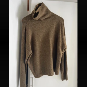  polotröja - Mysig brun polotröja med hög krage och lång ärm. Tröjan är stickad i ett mjukt ullmaterial och har en avslappnad passform. Perfekt för kyliga dagar när du vill vara både varm och snygg.