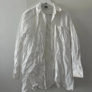 Vit klassisk skjorta i bomull - Vit skjorta i klassisk modell med lång ärm och knappar framtill samt vid manschetten. Skjortan har en bröstficka. Har fläckar, se bilder 