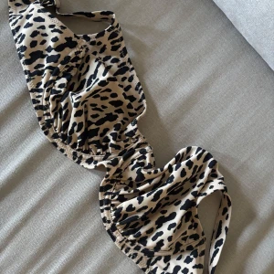 Leopardmönstrad bikini från Åhléns. Prislapp finns kvar  - Snygg bikiniöverdel från Åhléns i leopardmönster med svarta fläckar på beige botten. Bikinin har justerbara axelband och bygel för extra stöd. Tillverkad i mjuk och stretchig syntet. Den passade inte mig alls. Storlek 80E. 