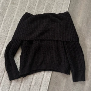 Svart offshoulder stickad tröja Gina Tricot - Svart stickad offshoulder-tröja från Gina Tricot. Tröjan har grovstickad struktur, lång ärm och bred krage som sitter snyggt över axlarna. Använd flera gånger och har mycket kvar till att ge. Hittar inga skönhetsfel. Normal tvättpåverkan.