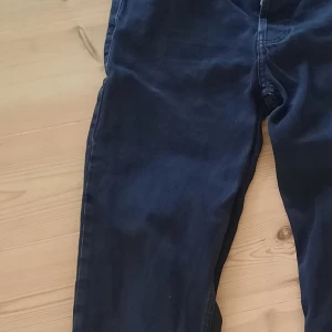 Svarta jeans Sweet SKTBS, stl 24 - Säljer ett par svarta jeans från Sweet SKTBS i storlek 24. Klassisk femficksmodell med knappgylf och silverfärgade nitar. Jeansen har en rak passform och är tillverkade i slitstarkt bomullstyg. Perfekta för dig som gillar en clean och tidlös look. Står strl 26 i vilket jag gissar är bredden (W), passar ngn som är 160-170 cm.