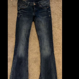 Bootcut jeans från H&M, blå denim - Snygga blå bootcut jeans från H&M i klassisk denim. Modellen har låg midja och lätt utsvängda ben. 
