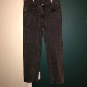Svarta raka jeans i vintage-look - Säljer ett par svarta jeans med rak passform och klassisk femficksdesign. Jeansen har en något tvättad vintage-look och är tillverkade i kraftigt denimtyg. Perfekta för dig som gillar en enkel och tidlös stil.