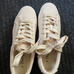 Beige sneakers från Duffy  - Snygga beige sneakers från Duffy med grov textilstruktur och breda snören. Skorna har en platt, högre platåsula och rund tå. Perfekta för dig som vill ha en stilren och trendig look med extra höjd.