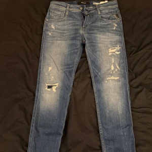 Blå Replay jeans. Storlek 30/32 - Säljer ett par blå Replay jeans med snygga slitningar och distressed detaljer . Ny pris på dessa är 1700. Storlek 30/32. Nästan som nya, använt 3 dagar efter jag fick dom sen inget mer.