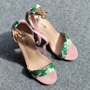 Blommiga klack-sandaler från JustFab - Färgglada sandaler med hög klack från JustFab. Skorna har blommigt och randigt mönster i grönt, rosa och vitt, med bred klack och öppen tå. Remmarna har guldfärgat spänne och materialet är mjukt tyg. Perfekta för att sticka ut i sommarens alla looks. Används ett fåtal gånger, något sletna vid klackslutet