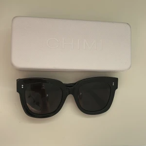 Svarta solglasögon från CHIMI - Snygga svarta solglasögon från CHIMI. Modellen har en klassisk, lite fyrkantig form och mörka glas. Kommer med originaletui. Nypris ca 1400kr!