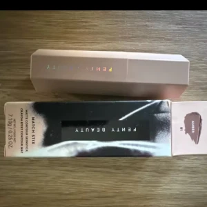 Fenty Beauty Match Stix Amber - Fenty Beauty Match Stix Matte Contour Stick i färgen Amber. Den har en krämig formula och kommer i en snygg, sexkantig beige hylsa med holografisk logga. Perfekt för att skulptera och definiera ansiktet med en naturlig finish.
