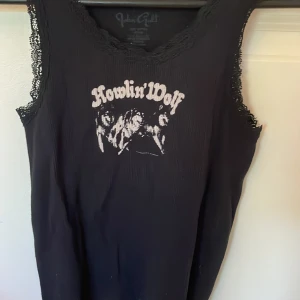 Svart linne med detaljer och tryck  - Linne med tryck från brandy Melville. Storleken är oklar men passar någon som har ungefär 134-152 (xxs/xs)