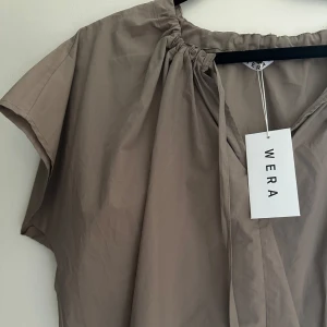 Blus Wera  - Säljer en ny Regan Blus från WERA fast i beige/brun. Färgen finns inte längre och är helt slutsåld. Köpt för 499kr