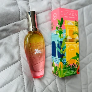 Escada Brisa Cubana parfym 50ml - Fräsch och tropisk parfym från Escada, Brisa Cubana. Flaskan har en snygg ombre-design i gult och rosa med silverfärgad kork. Kommer i en färgglad kartong med tropiska motiv. Limited edition, 50 ml Eau de Toilette.