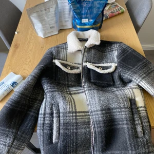 Rutig teddyjacka från Manière De Voir - Säljer en sjukt snygg teddyjacka från Manière De Voir i svart, grått och vitt rutigt mönster. Riktigt fet och i riktigt fint skick perfekt till hösten sitter tts