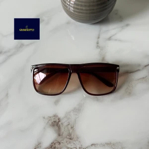 Bruna  solglasögon - Snygga solglasögon  med rektangulär form och bruna bågar. Glasen har en snygg brun toning som ger en cool vibe. Perfekta för att lyfta din stil under soliga dagar.